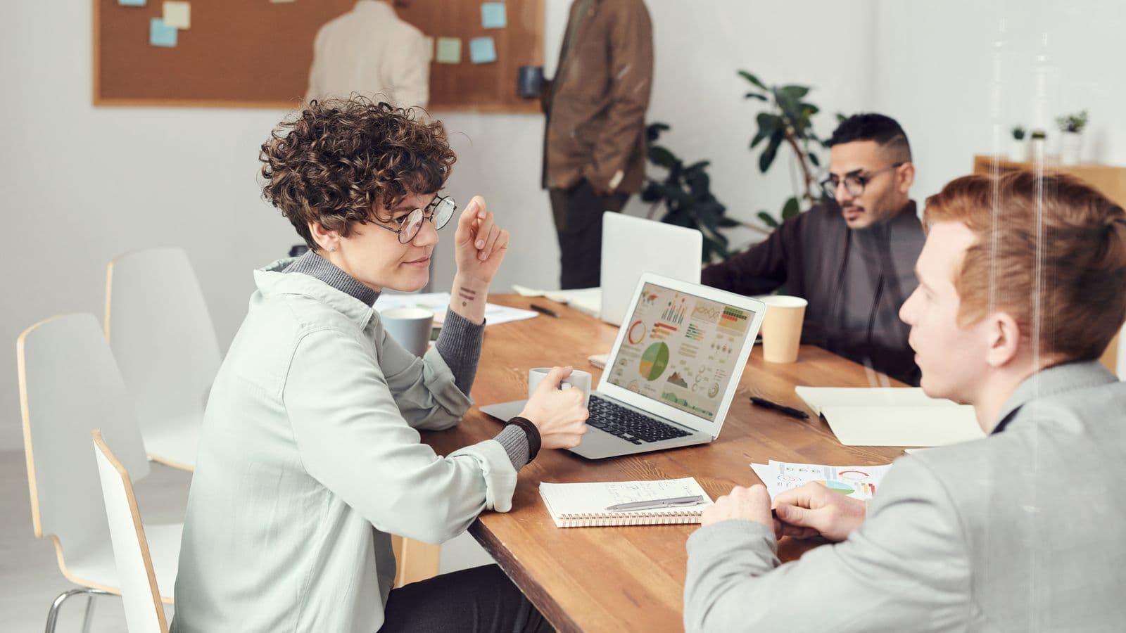 Colleagues discussing technology plans around a laptop
