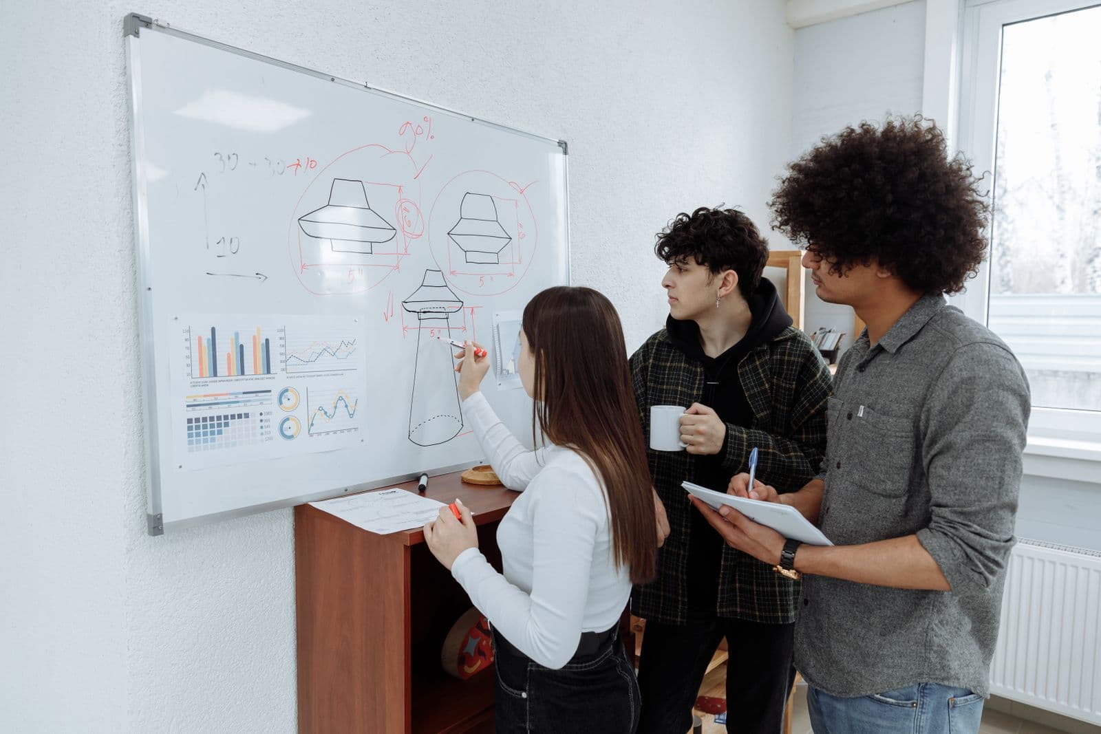 Design team mapping product workflows on a whiteboard